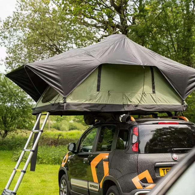 Alpine 2 rooftop tent deployed on a Fiat Panda Cross in a green woodland setting
